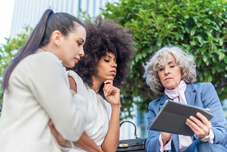 three female workers studying company information in the city